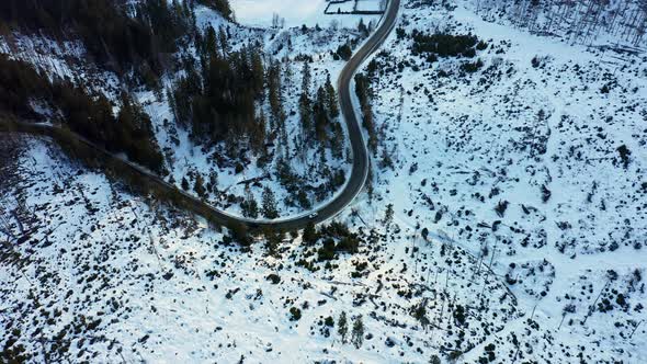 Car driving on frozen mountain road in winter season, Tatry landscape. Aerial view