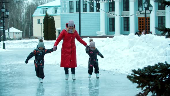 A Young Family of Mother and Two Children Skating on the Public Ice Rink