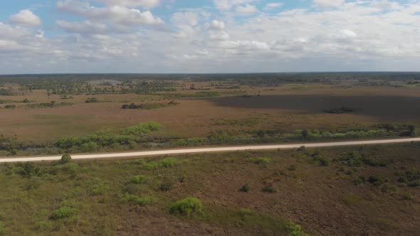clouds moving across wetland swamp grass horizon vast road everglades florida aerial drone