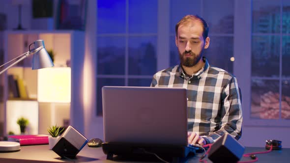 Young Man Working Late Night Hours From His Home Office