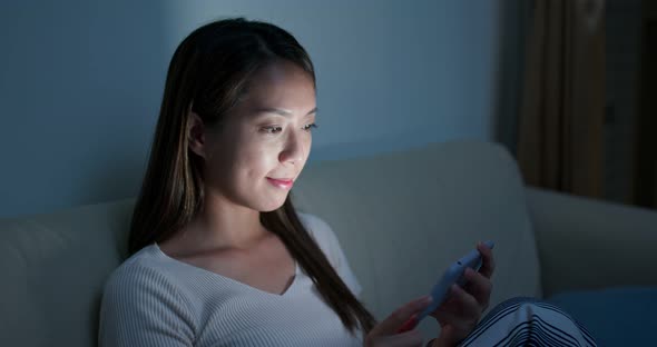 Woman watch on cellphone at home in the evening