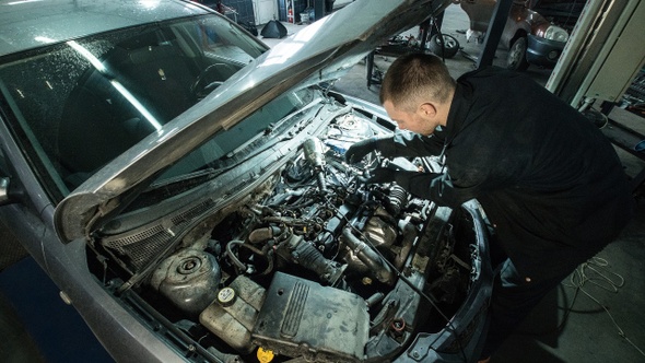 Timelapse, two mechanics repairing under the hood of the car