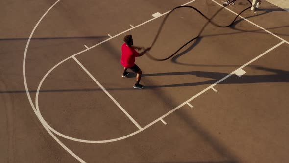 Aerial shot of a man working out with battle ropes