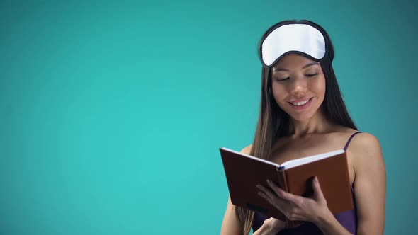 Beautiful Woman in Pajamas Reading Book in Bed, Falling Asleep After Tired Day