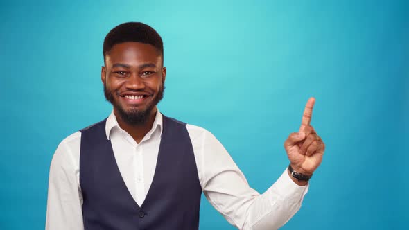 African American Man Pointing Up to Copy Space for Advert Blue Background