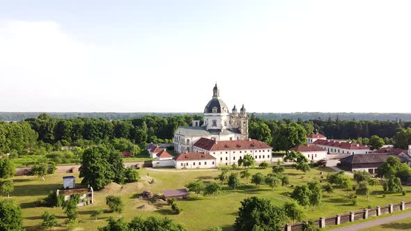 Pazaislis monastery complex building with majestic dome in descend behind bush drone view