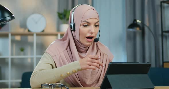 Arabic Woman in Headscarf which Holding Online Webinar Applying Headset while Working Distantly