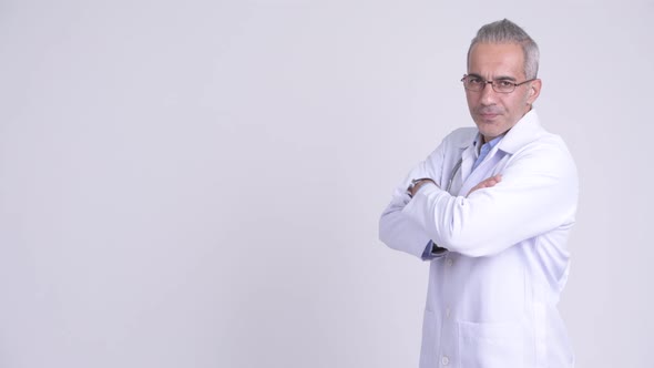 Profile View of Happy Persian Man Doctor Looking at Camera