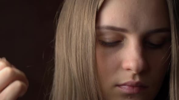 Face of a Beautiful Young Woman Straightening Her Hair Behind Her Ear