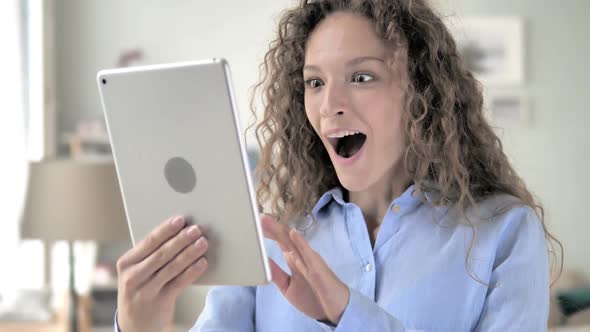 Curly Hair Woman Celebrating Success on Tablet