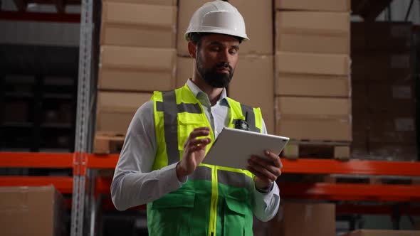 Inventory Manager Working on Tablet in Storehouse