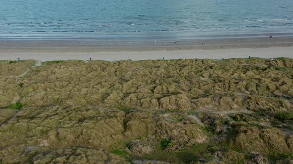 Drone moving backward revealing Irish beach.