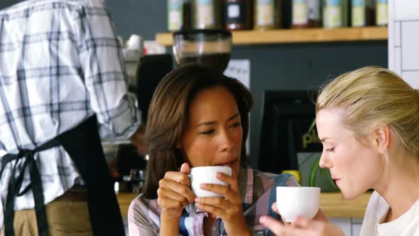 Women interacting with each other while having coffee