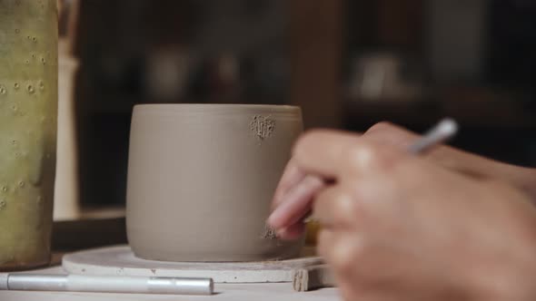 Young Woman Potter Making Ribs for Attaching a Handle to a Cup Made Out of Clay