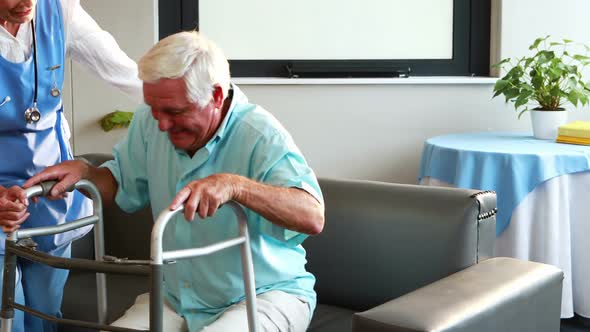 Nurse helping retired man with walker