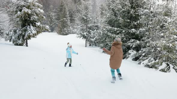 Happy Kids Running on Snowy Spruce Forest