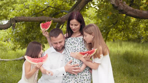 Positive Caucasian Family in Summer Clothes Posing Together at Green Garden and