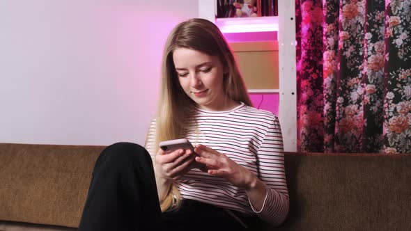 Portrait of a Girl Who Sits on the Couch and is Interrupted By Her Phone