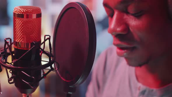 Close-Up of Black Hip-Hop Singer Recording Song in Home Studio