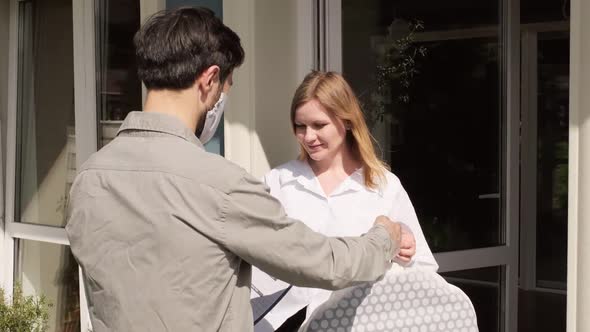 Cheerful Woman Receiving Dry Cleaning from Delivery Man