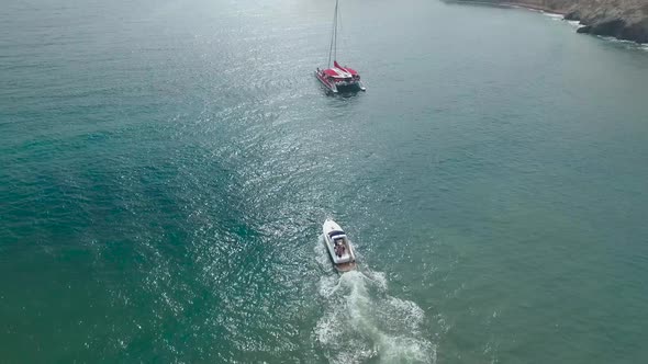 Boats near Red Beach on Santorini Island in Greece - drone view