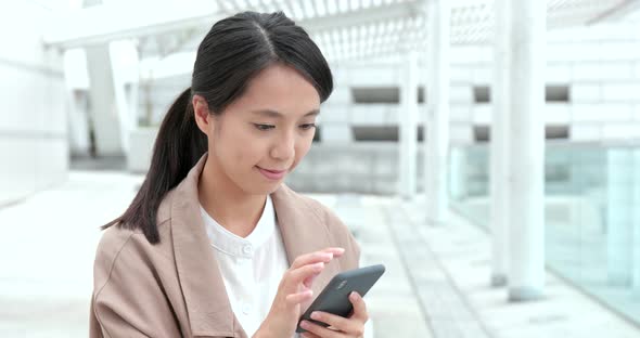 Woman using mobile phone in city at outdoor