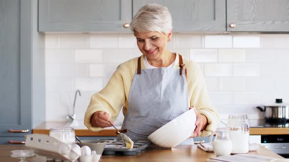 Woman Putting Batter Into Baking Molds on Kitchen