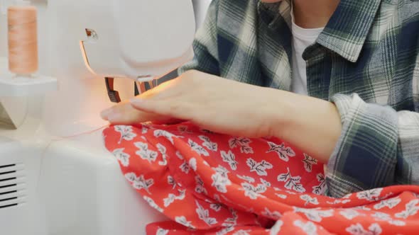 Closeup of woman's hands sewing on overlock.