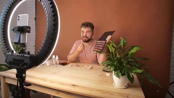 Young Man Filming His Video Blog Episode About New Cosmetic Products While