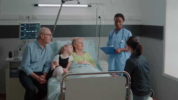 African American Nurse Giving Advice to Patient with Disease and Family in Visit