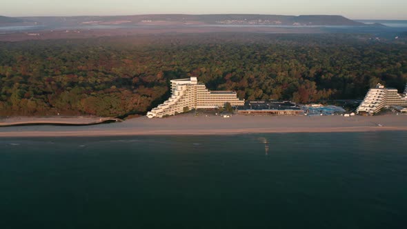 Drone flight over empty sandy beach and coastal hotels