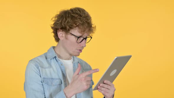 Redhead Young Man Loss on Tablet Yellow Background