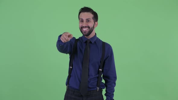 Happy Young Bearded Persian Businessman Pointing Finger and Looking Surprised