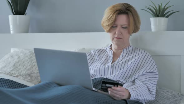 Online Shopping on Laptop By Old Senior Woman in Bed Payment