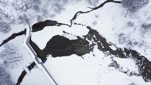 People crossing little bridges over stream at Kuznice, Poland. Aerial top-down rising