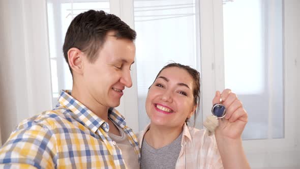 Happy Family with Keys of New Apartment Makes Selfie in Room