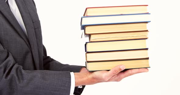 Mid section of businessman stack of books