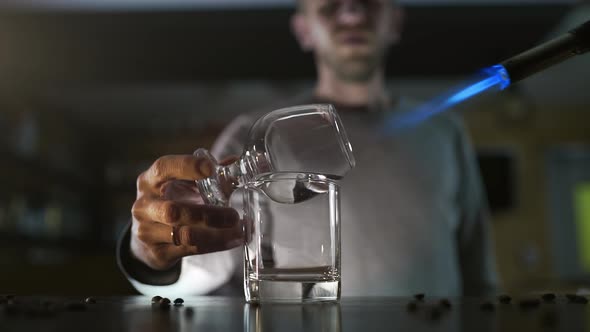 Bartender Fires Up the Sambuca with Gas Burner, Making Cocktails in a Bar, Alcohol Drink