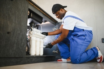 Plumber installs or change water filter. Replacement aqua filter.