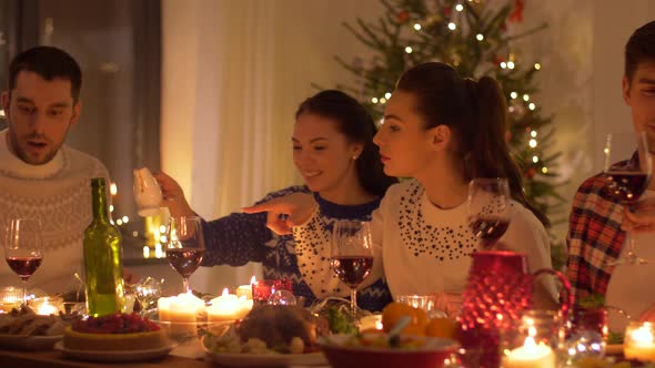 Happy Friends Having Christmas Dinner at Home