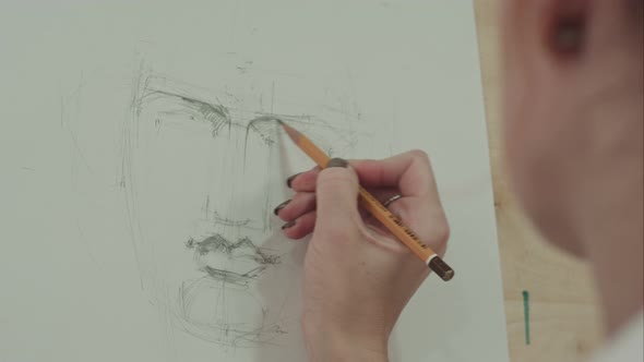 Concentrated Woman Artist Painting Classical Man Portrait with Pencil