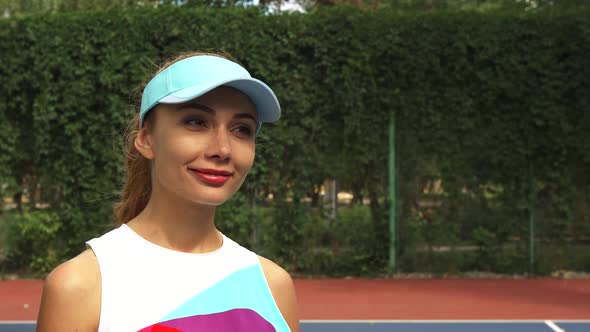 Girl with a Racket Smiling and Looking at Camera