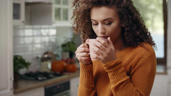 Young woman drinking hot tea in autumn time