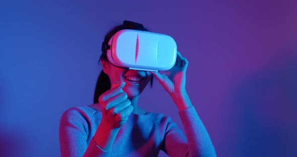 Woman looking though virtual reality device over red and blue light