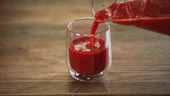 man pours tomato juice into a glass. drink for breakfast. vegetarian drink for health and energy