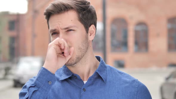 Sick Young Man Coughing While Standing Outdoor
