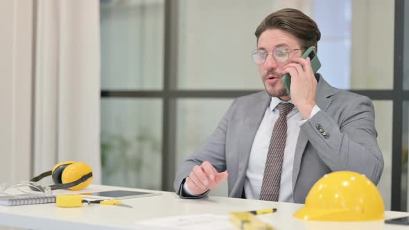 Middle Aged Engineer Talking on Phone in Office