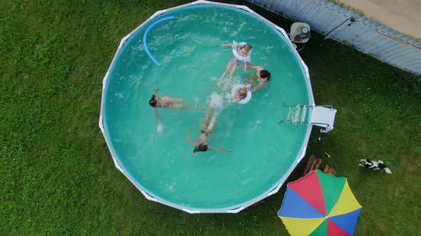 Aerial Shooting of Children Swimming in the Round Swimming Pool in the Backyard