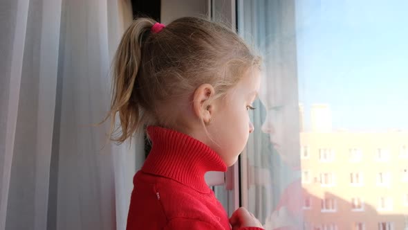 Little Sad Girl Looking Out of the Window