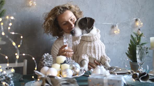 Young Woman Sitting With Funny Dog At Table On Christmas